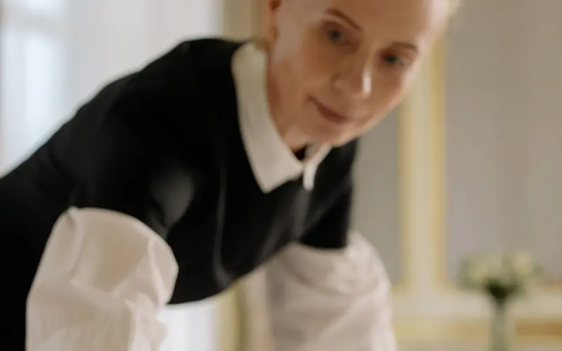 Housekeeper preparing a guest-ready bed for a short-term rental turnover