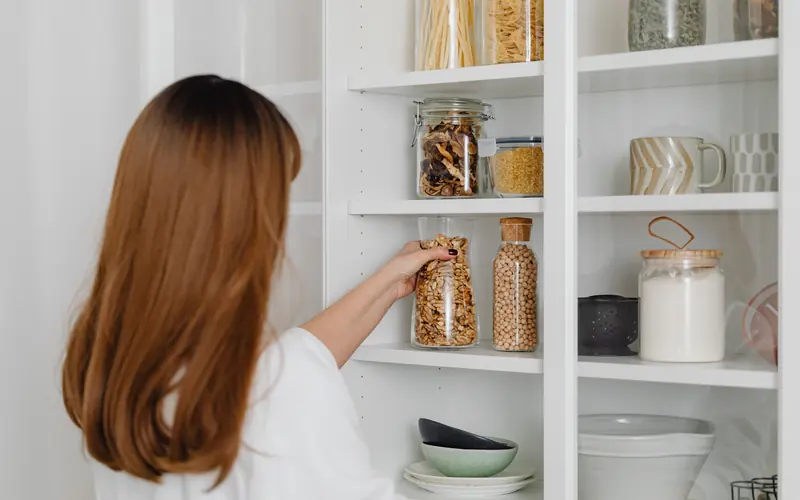 Organized pantry shelves with clear storage jars